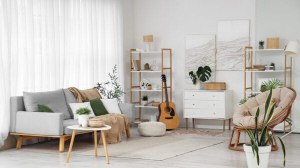 Interno di soggiorno luminoso con divano, poltrona e piante