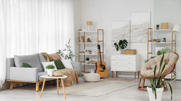 Interno di soggiorno luminoso con divano, poltrona e piante