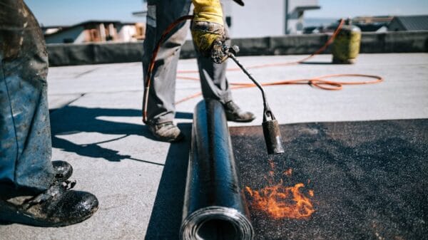 operai che posano guaina bituminosa