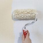 mano che regge un rullo con pittura