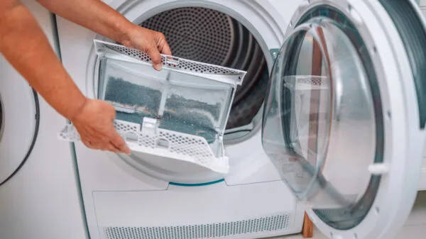 mani che estraggono il filtro dell'asciugatrice