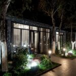Vialetto illuminato di notte con luci LED da giardino davanti a edifici moderni con ampie vetrate e piante decorative
