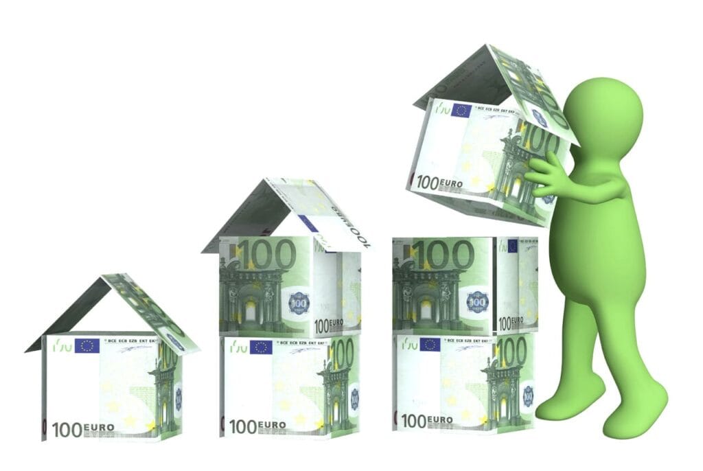 omino che costruisce case con banconote da 100 euro