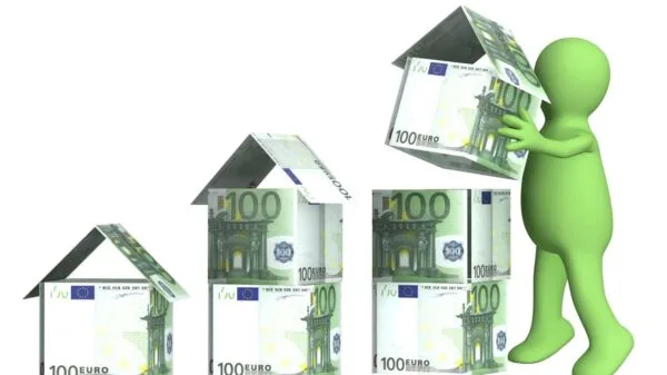 omino che costruisce case con banconote da 100 euro