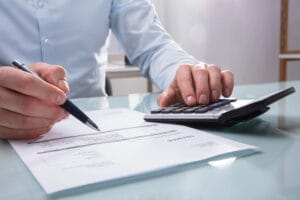 Foto della mano di persona che calcola la fattura con il calcolatore