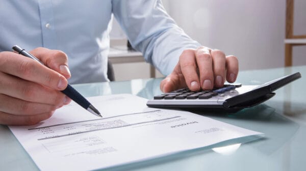 Foto della mano di persona che calcola la fattura con il calcolatore