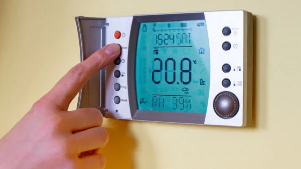 Primo piano della mano di una donna che imposta la temperatura ambiente su una termostato