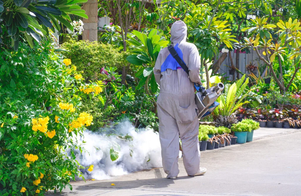operaio che effettua disinfestazione di un giardino