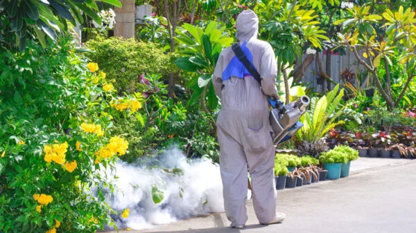 operaio che effettua disinfestazione di un giardino